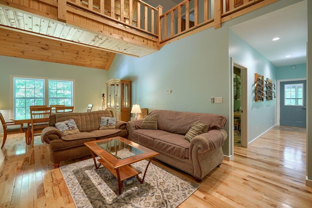 living room with beam ceiling, high vaulted ceiling, light hardwood / wood-style flooring, and wood ceiling