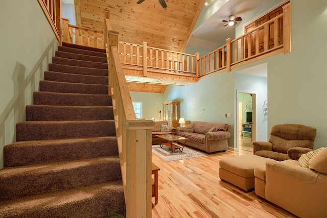 staircase with hardwood / wood-style flooring, high vaulted ceiling, ceiling fan, and wooden ceiling