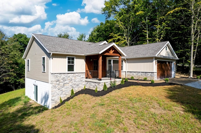 view of front of home with a front lawn, a garage, and roof with shingles