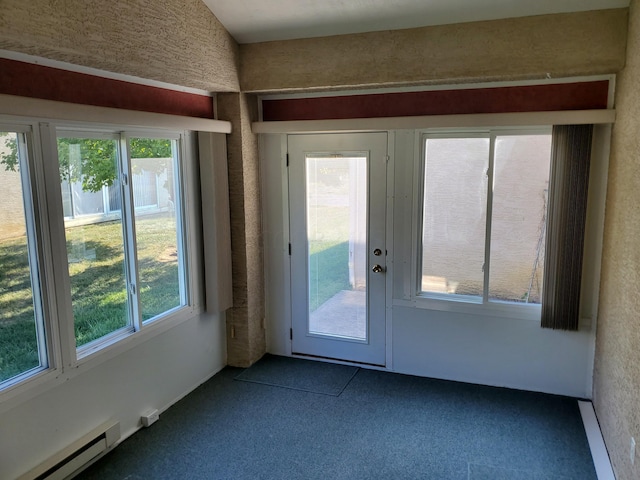 doorway to outside featuring carpet flooring, a healthy amount of sunlight, and a baseboard heating unit