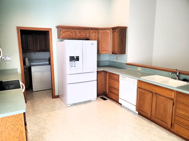 kitchen featuring washer / dryer, white appliances, and sink