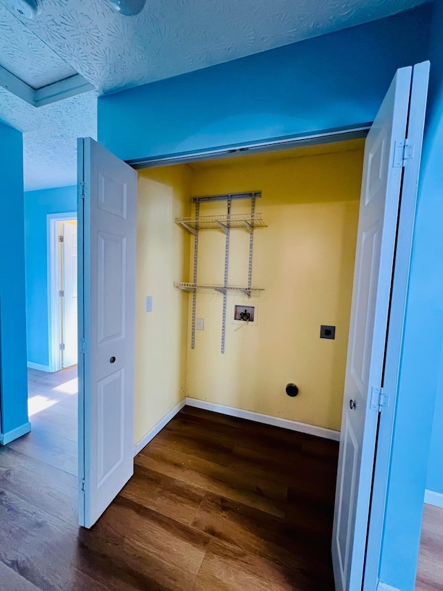 laundry area with electric dryer hookup, wood-type flooring, a textured ceiling, and washer hookup