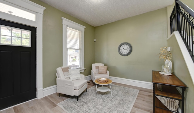 entryway featuring a healthy amount of sunlight, a textured ceiling, and light hardwood / wood-style flooring