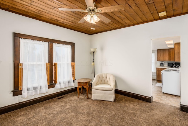 sitting room with washer / dryer, light colored carpet, and wood ceiling