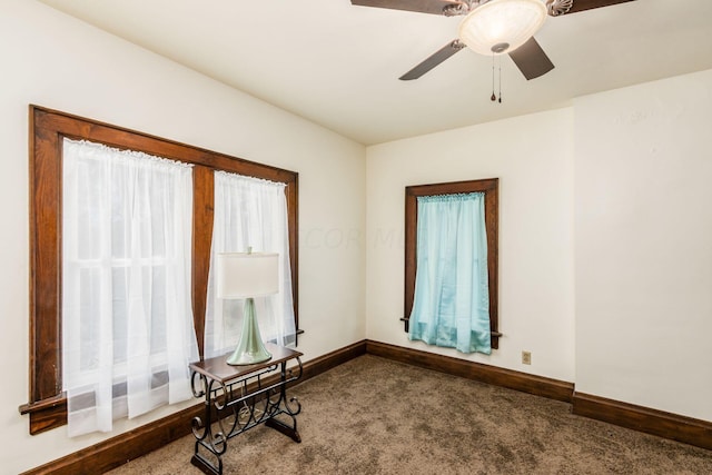 carpeted spare room with ceiling fan