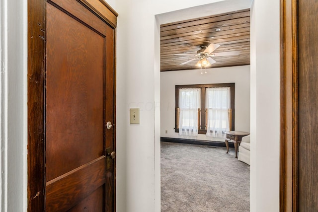 hall featuring carpet flooring, french doors, and wooden ceiling