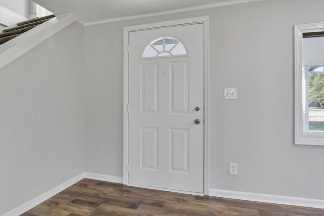 foyer entrance with a textured ceiling, dark hardwood / wood-style flooring, plenty of natural light, and ornamental molding