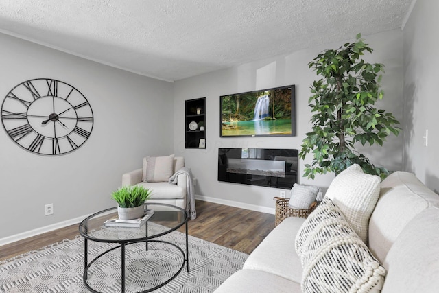 living room featuring built in features, hardwood / wood-style floors, and a textured ceiling