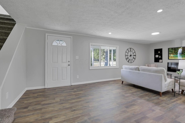 living room with a textured ceiling and dark hardwood / wood-style flooring