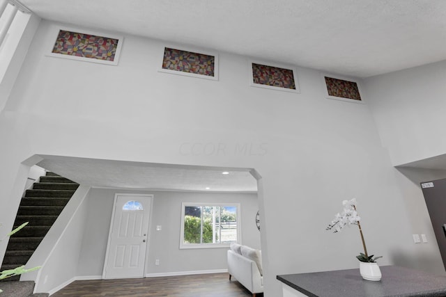 foyer entrance featuring a textured ceiling and dark wood-type flooring