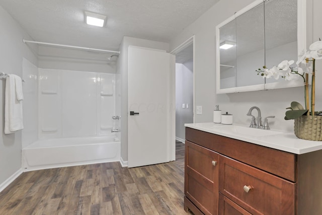 bathroom featuring vanity,  shower combination, wood-type flooring, and a textured ceiling