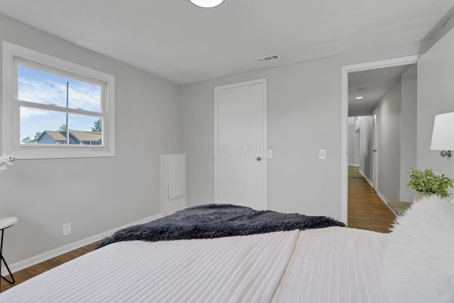 bedroom with dark hardwood / wood-style flooring