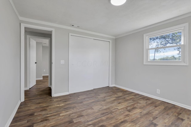 unfurnished bedroom with dark hardwood / wood-style floors and crown molding