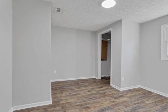 empty room featuring hardwood / wood-style flooring and a textured ceiling