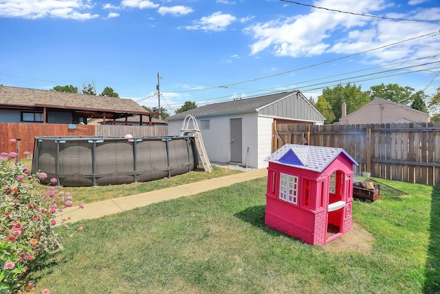 view of yard with a fenced in pool and a storage shed