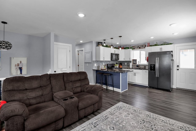 living room featuring sink and dark hardwood / wood-style flooring