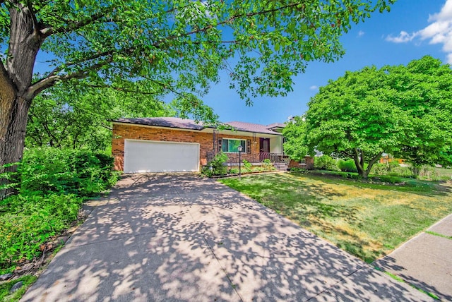 view of front of property featuring a front yard, a porch, and a garage