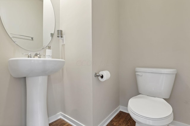 bathroom featuring toilet and wood-type flooring