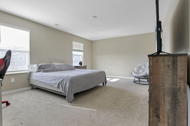 carpeted bedroom featuring multiple windows