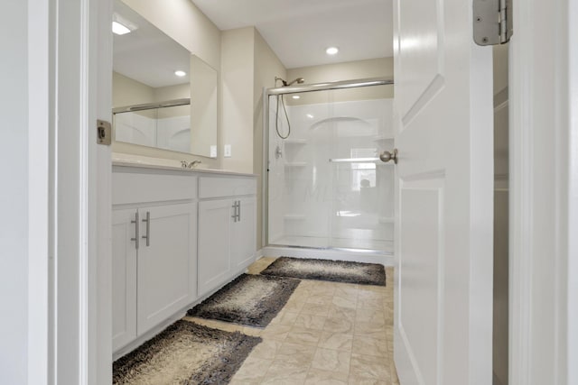 bathroom featuring vanity and a shower with shower door