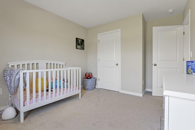 bedroom featuring a crib and light colored carpet