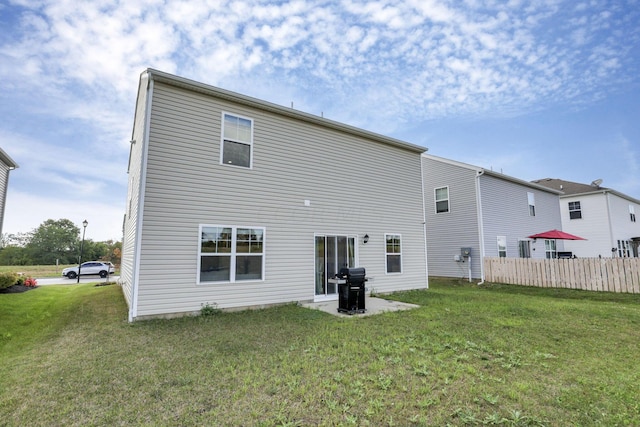 rear view of property featuring a lawn and a patio area