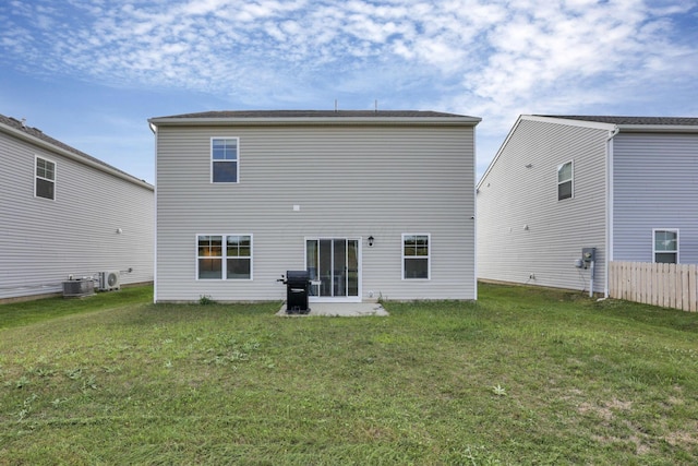 rear view of property with a yard and central AC