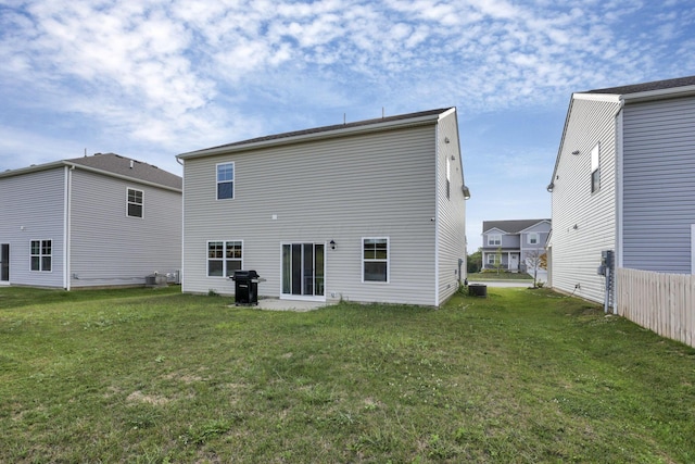 rear view of property featuring a lawn and central AC