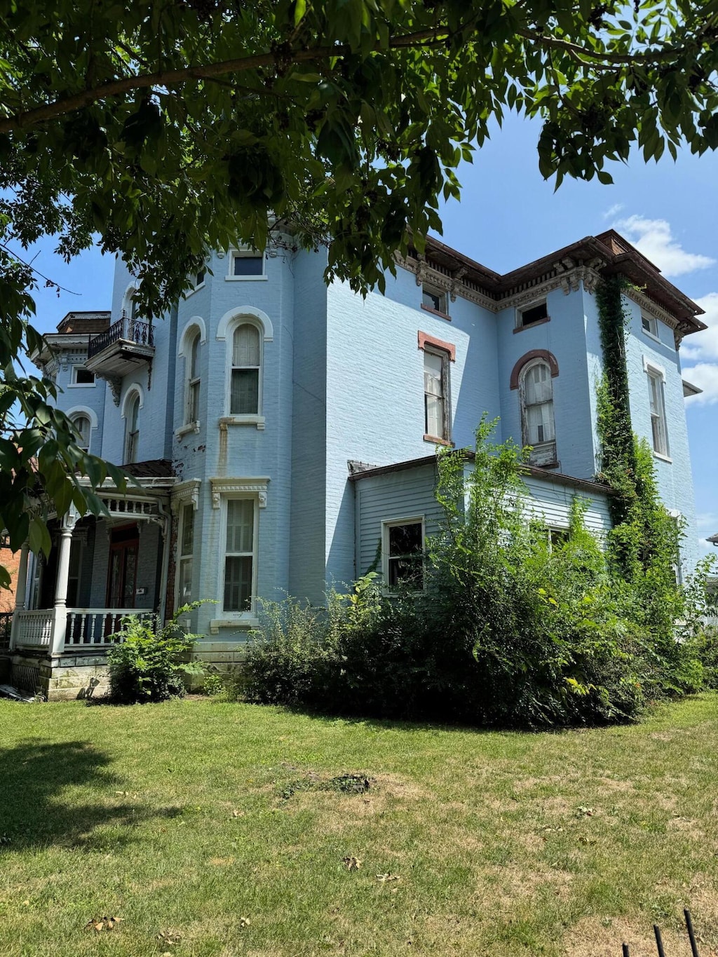 rear view of house with covered porch and a yard