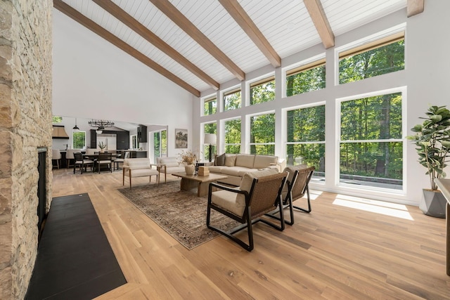 living room with beam ceiling, wooden ceiling, high vaulted ceiling, and light hardwood / wood-style floors