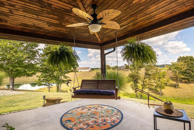 view of patio with ceiling fan and a water view