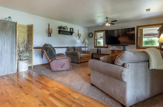 living room with hardwood / wood-style floors, a textured ceiling, a wealth of natural light, and ceiling fan