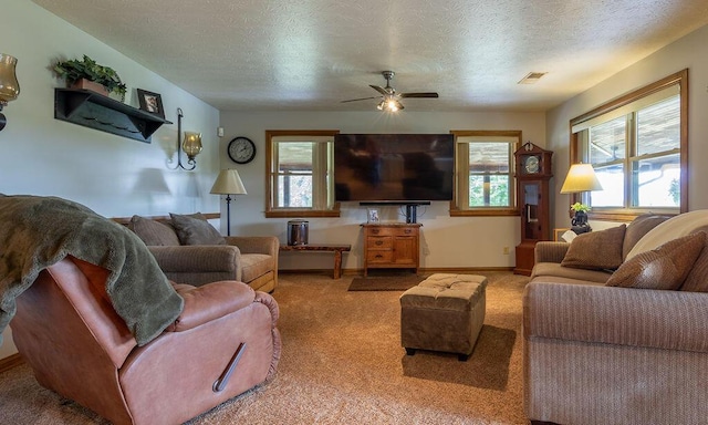 carpeted living room featuring ceiling fan and a textured ceiling