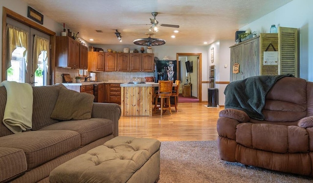 living room with ceiling fan and light hardwood / wood-style floors