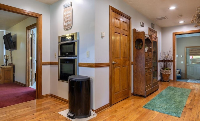 hallway with light hardwood / wood-style floors