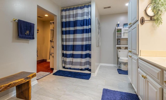 bathroom featuring vanity, toilet, and curtained shower