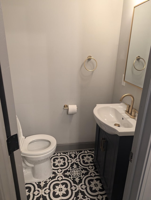 bathroom with tile patterned flooring, vanity, and toilet