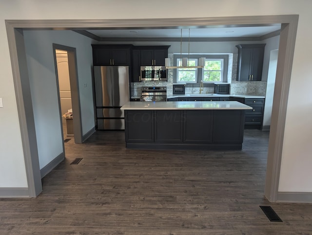 kitchen with backsplash, sink, a kitchen island, and stainless steel appliances