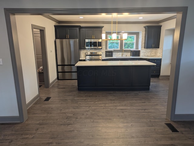 kitchen with dark hardwood / wood-style flooring, a center island, stainless steel appliances, and backsplash