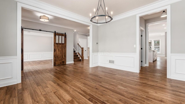 unfurnished dining area with an inviting chandelier, a barn door, dark hardwood / wood-style flooring, crown molding, and a textured ceiling