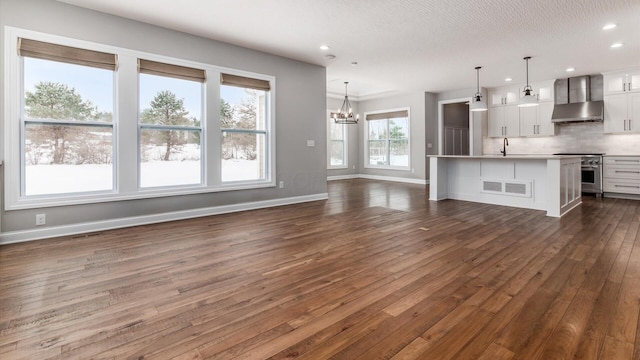 unfurnished living room featuring dark hardwood / wood-style flooring and an inviting chandelier