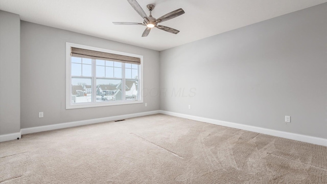 empty room featuring ceiling fan and carpet