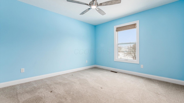 carpeted spare room with ceiling fan