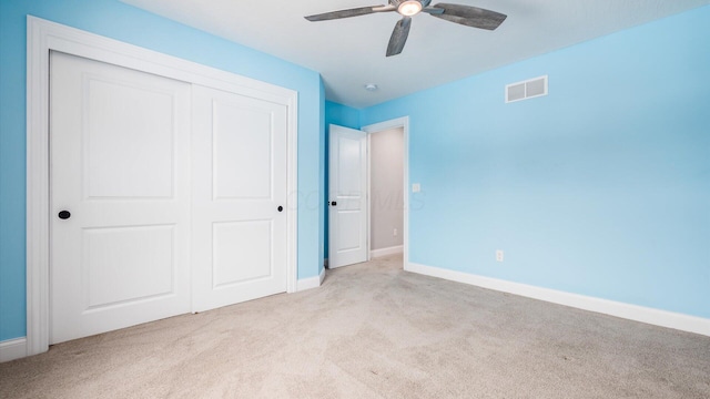 unfurnished bedroom with light colored carpet, a closet, and ceiling fan