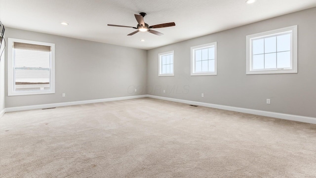 unfurnished room featuring ceiling fan and light carpet