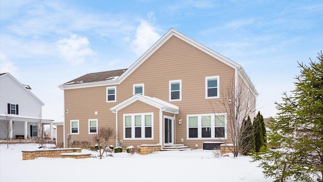 view of snow covered rear of property