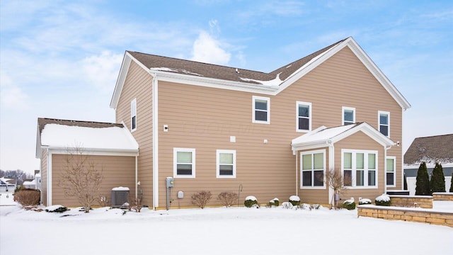 snow covered rear of property with central air condition unit