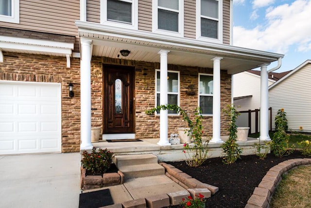 view of exterior entry with a porch and a garage