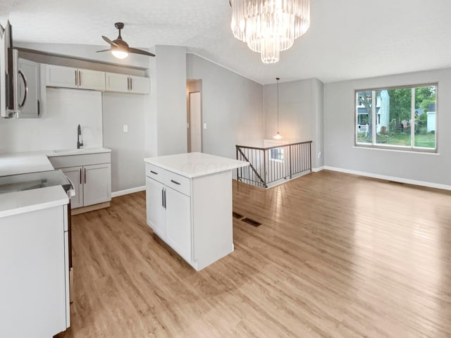 kitchen featuring sink, a center island, light hardwood / wood-style flooring, decorative light fixtures, and ceiling fan with notable chandelier