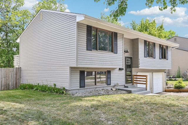 raised ranch featuring a garage and a front lawn